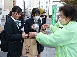 農産物の詰め合わせを配付する大島議長（右）