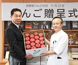 宮下統括院長（右）に渡す栗林組合長（左）