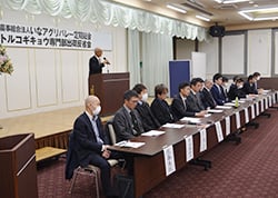 壇上であいさつする山崎専門部長