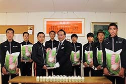農産物を贈り選手を激励する高栁副組合長（11月27日、佐久市岩村田の駅伝部宿舎で）