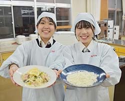 考案したレ料理と手作りのアルファ米をアピールする多武さん（右）と熊谷さん（左）（長野県飯田市で）