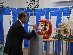 だるまの目入れをする春日理事