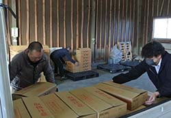 持ち込まれた市田柿を荷下ろしする生産者とJA職員