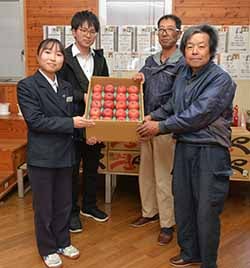 村山部長（右下）と同部会の唐澤副会長（右上）からりんごを受け取る安部生徒会長（左下）と代田裕也教諭（左上）