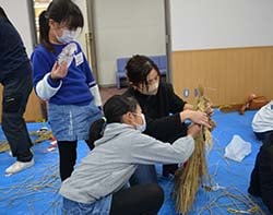 家族で協力してしめ飾りをつくる様子