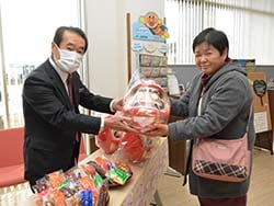 福だるまを手渡す中川栄治理事（左）と来場者