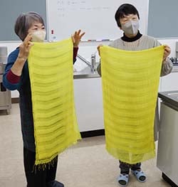 できあがった黄色のストールを見せ合う受講生