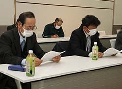 真剣な表情で確認を行う出席者