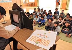 真剣に紙芝居を見る園児ら