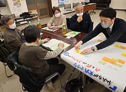 SDGsについて話し合い、意見を模造紙にまとめる参加者