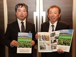 記念誌を手にする百瀬部会長（右）と五味係長