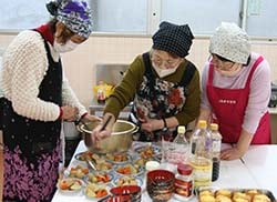協力して煮物を盛りつける部員