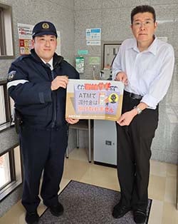 宮川巡査部長（右）から鮎沢所長へ「注意喚起シート」の受け渡しを行ったJA湖南営業所
