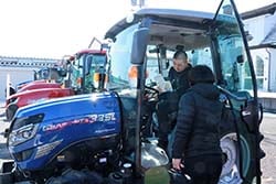 トラクターの説明を聞く来場者
