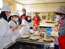 女性部員の指導で楽しく五平餅づくりをする児童ら
