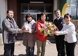 原小学校長らと「harahana花育プロジェクト」のメンバーにアルストロメリアとアネモネを届ける宮坂支部長（右から3番目）と鎌倉副支部長（左）
