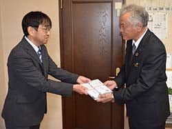 クレパスを渡す井口理事と受け取る辰野教頭