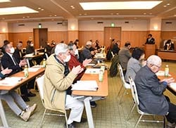 拍手で議案を承認する会場