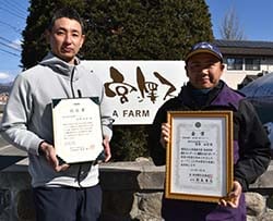 世界最高米の認定書を持つ宮澤取締役（左）と従業員（右）（安曇野市三郷）