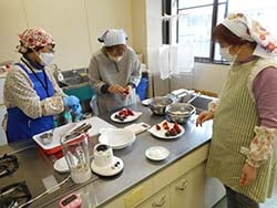 生地でイチゴを包む参加者