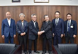 力強く握手で今後の協力を確認した松下協議会長（中央左）
