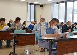 赤かび病の発生条件やポイントの説明を聞く生産者
