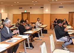 拍手で議案を承認する会場