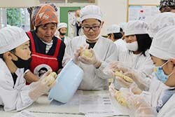 潰した大豆を団子状に丸める児童