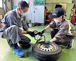 タイヤの空気圧を確認する生徒（右）