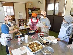 『家の光』を使って料理する参加者