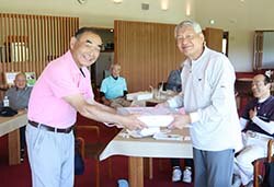 藤森順三副支部長（左）から記念品を受け取る優勝した松澤さん（右）