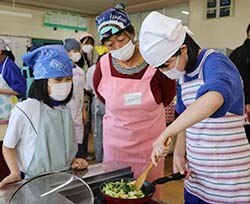 宮沢支部長に見守られながら料理をつくる児童たち（21日、長野県東筑摩郡山形村で）