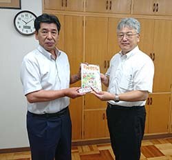 ちゃぐりんと箸セットを手にする寺澤専務（左）と細山校長先生（右）（長野県塩尻市で）
