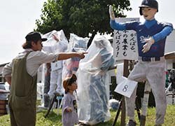 名物のかかしを眺める親子