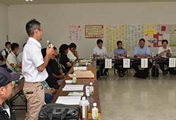 市場担当者に意見を述べる生産者（左）