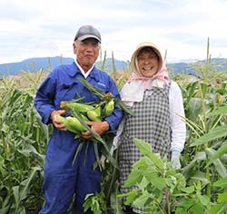 笑顔でスイートコーンを抱える永田さん(左)と百瀬さん(右)