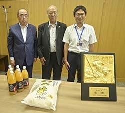 米とリンゴジュースを贈る宮澤組合長（中）ら