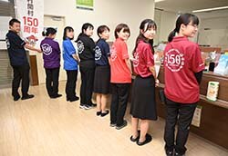 開村150周年を祝い記念ポロシャツを着用する職員ら