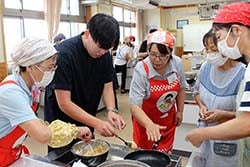 こねつけをの焼き方の指導を受ける教員