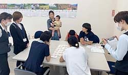 防災カードゲームを行うJAみなみ信州フレッシュミズメンバーと、視察するJA信州諏訪の職員