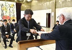 宮澤清組合長（右）から任命書を受け取る検査員（左）