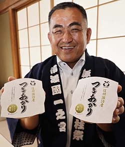 「信州諏訪産つきあかりオリジナルパックご飯」の完成を報告する熊谷課長