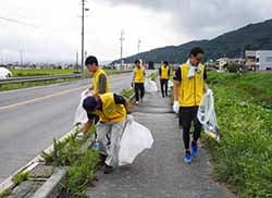 道路わきのごみを拾い集める参加者
