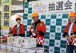 抽選をする長谷川会長（中央）