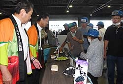 JA役員が仲卸に試食をすすめる