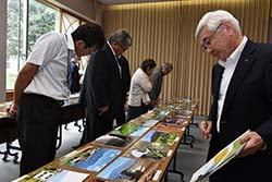作品を審査する宮澤清組合長（右）と審査員ら（安曇野市豊科）