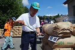 「穀刺し」を刺してサンプル米を取り出す検査員