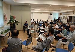 見本を手に取り出荷規格を説明する職員