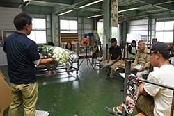 出荷された花束を見本に規格を説明する営農技術員