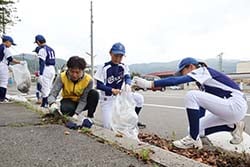 協力して清掃活動をする「長地ファイヤードラゴンズ」の児童とJA職員